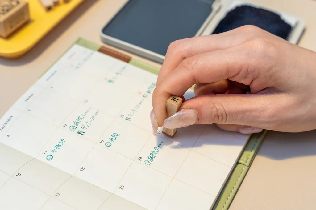 手帳にスタンプと同じ色で文字を書いている様子