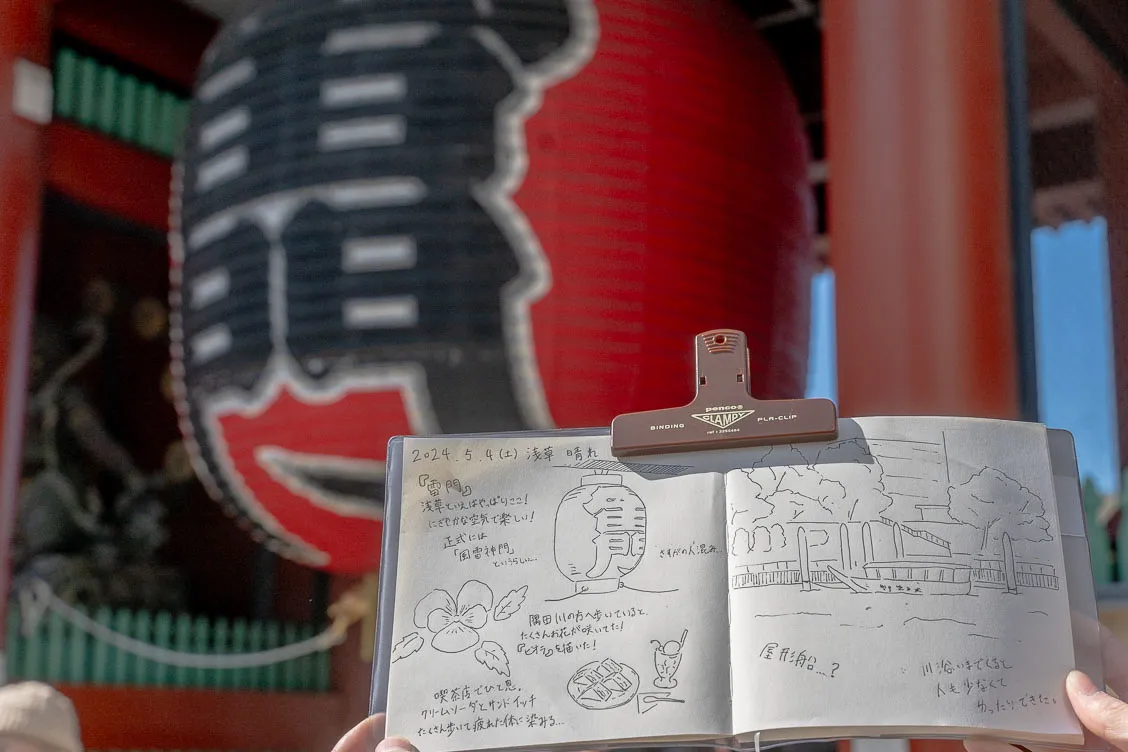 雷門の前でスケッチしたノートを開いている様子