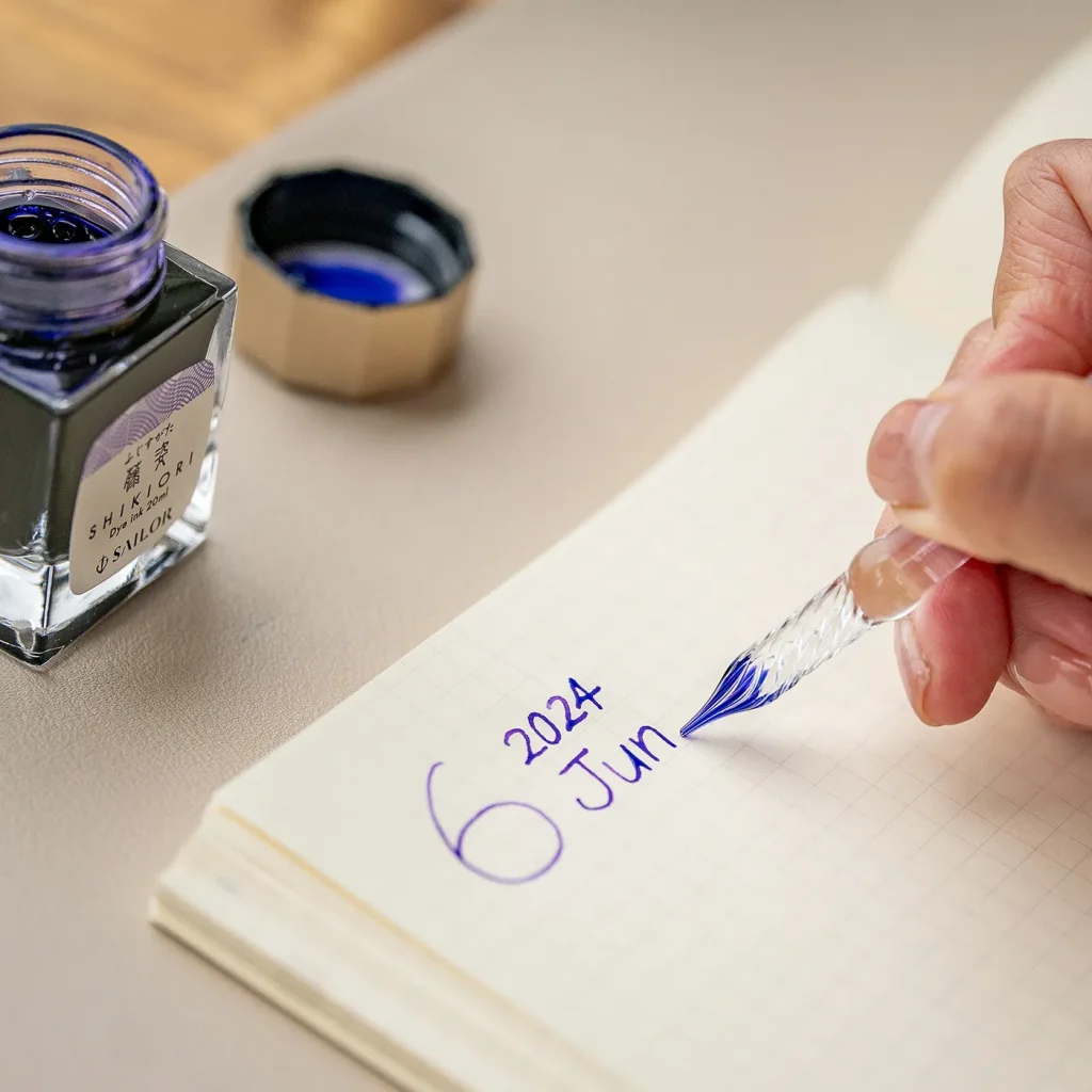 太字のガラスペンで見出しを書いている様子