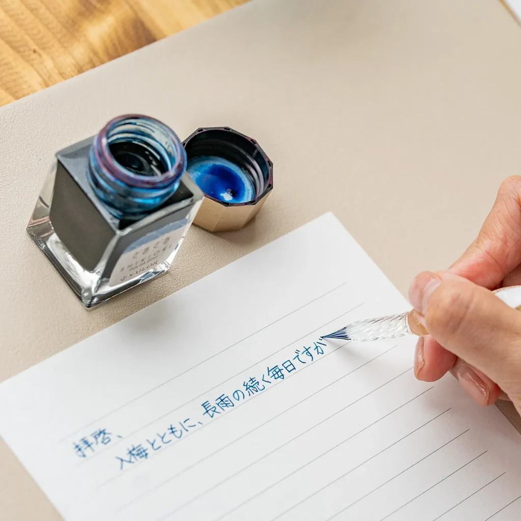 中字のガラスペンで手紙を書いている様子